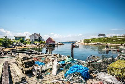 Boats moored at harbor against blue sky