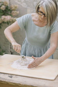 Midsection of woman holding ice cream on table