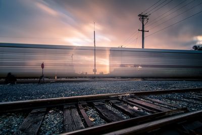 Railroad tracks against sky during sunset