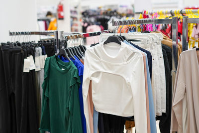 Colorful women's clothes on hangers in a retail shop. fashion and shopping concept