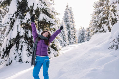 Full length of woman standing on snow covered field