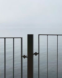 Railing by sea against sky