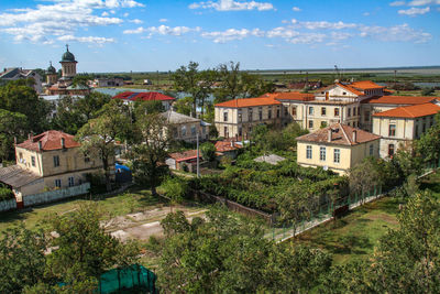 Town by trees against sky