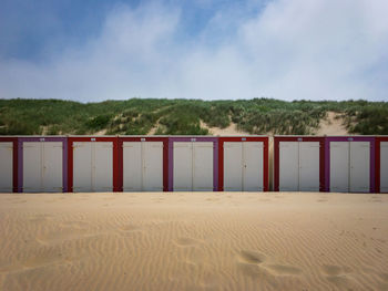 Colorful beach cabins at north sea beach of domburg, zeeland, the netherlands against sky