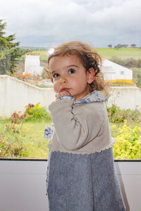Portrait of cute girl standing against sky