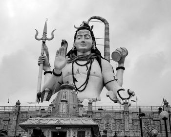 Low angle view of statue against building against sky