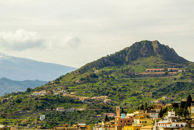 Houses on mountain against sky