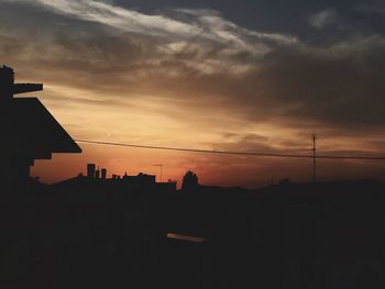 Low angle view of silhouette buildings against sky at sunset