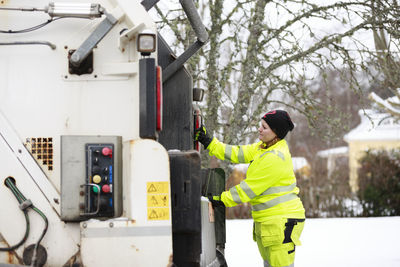 Woman operating garbage truck