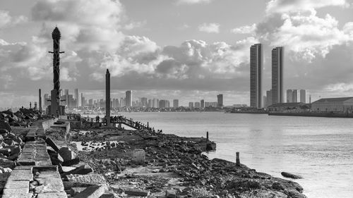 View of cityscape against cloudy sky