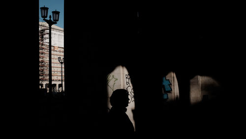 Silhouette woman standing by window in building