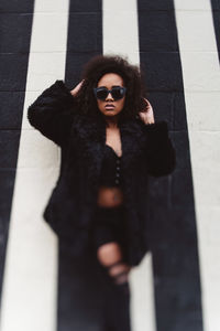 Portrait of young woman wearing sunglasses standing outdoors