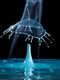 Close-up of water drops on glass over black background