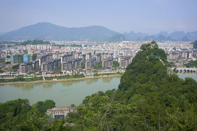 Aerial view of buildings in city against sky