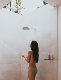 Woman in bikini in the tropical shower