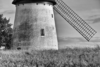 Low angle view of windmill on field against sky