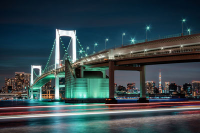 View of bridge over river at night