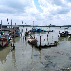 Boats moored in sea against sky