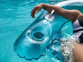 Midsection of woman swimming in pool