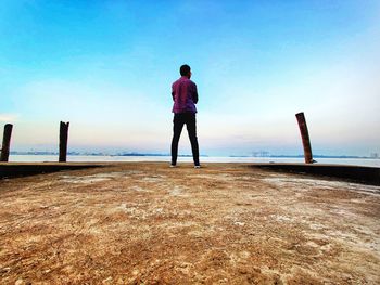 Rear view of man looking at sea against sky