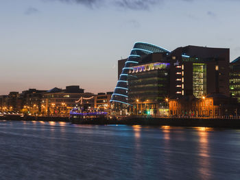 Illuminated buildings along river liffey in dublin