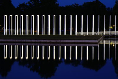 Reflection of silhouette trees in lake at night