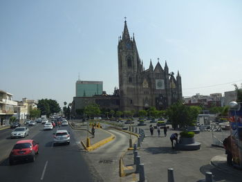 Vehicles on road amidst buildings against sky