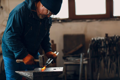 Side view of man working in workshop