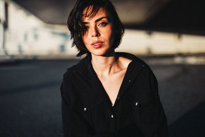 Portrait of beautiful woman standing against blurred background