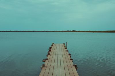 Pier over lake against sky