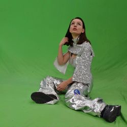 Portrait of teenage girl sitting against green background