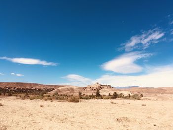 Scenic view of desert against blue sky