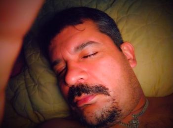 Close-up portrait of man relaxing on bed at home