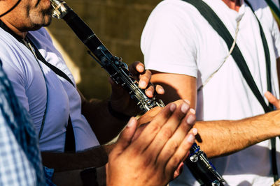 Midsection of people playing saxophone