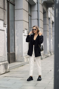 Full length of young woman standing in city