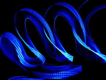 Close-up of blue light painting against black background