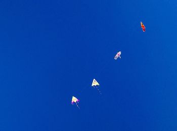 Low angle view of flag against clear blue sky