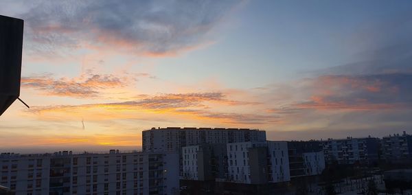 Low angle view of buildings against sky during sunset