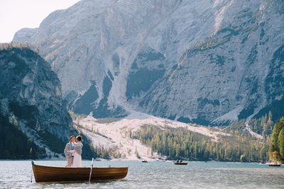 Woman on boat in lake against mountains