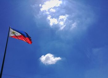 Low angle view of flag against blue sky