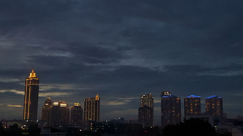Illuminated cityscape against sky at night