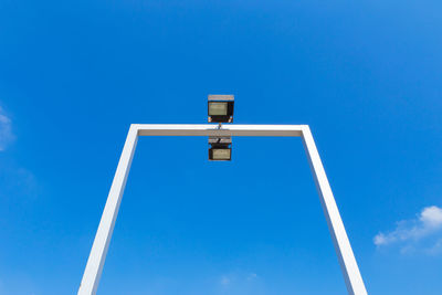 Low angle view of sign against blue sky