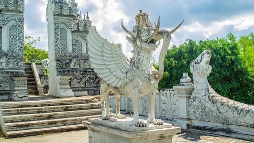 Statue of historic building against cloudy sky