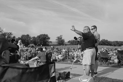 People playing at music concert against sky