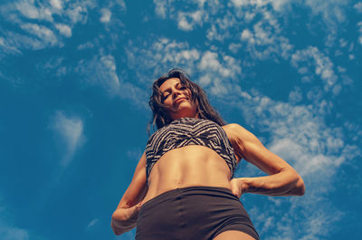 Low angle view of woman standing against sky
