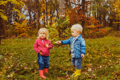 Full length of father and son on tree during autumn