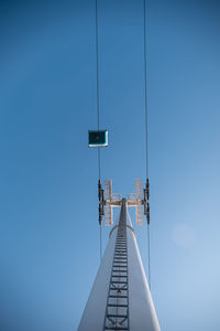 Low angle view of communications tower against clear blue sky