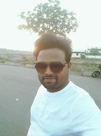 Portrait of young man wearing sunglasses standing outdoors