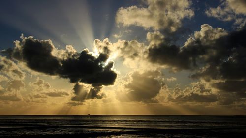 Scenic view of sea against dramatic sky during sunset