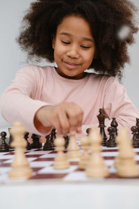African american girl playing chess happy child behind chess smiling in class excited  black kid